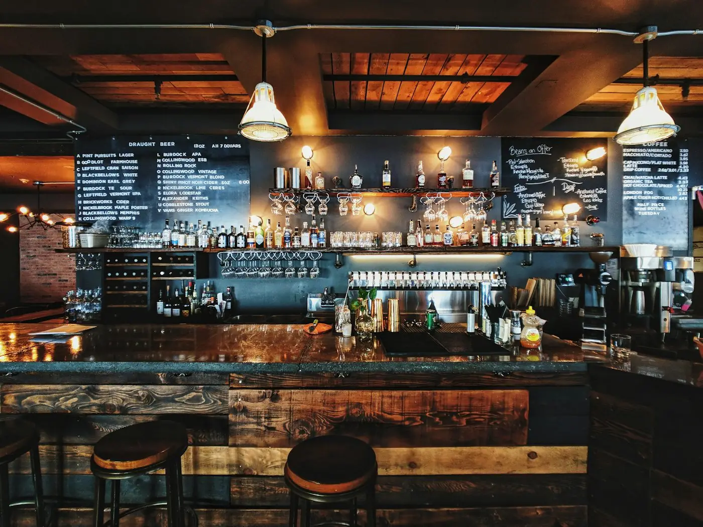 A bar at night with chalkboard menus and stools