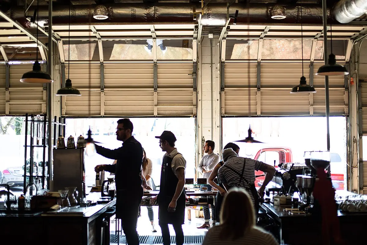 Baristas making drinks behind the counter of a busy cafe