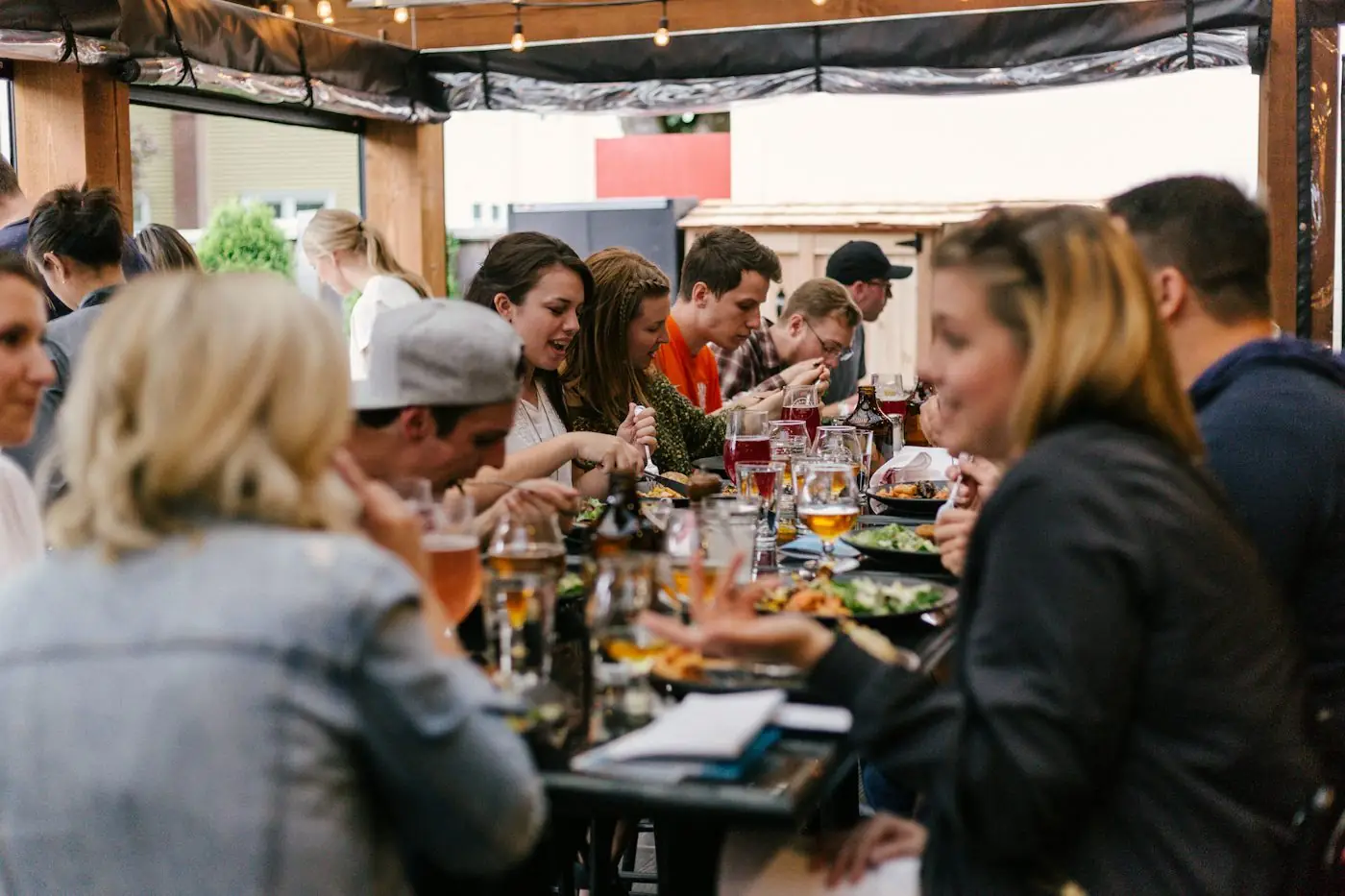 Friends sharing dinner and drinks at a long table