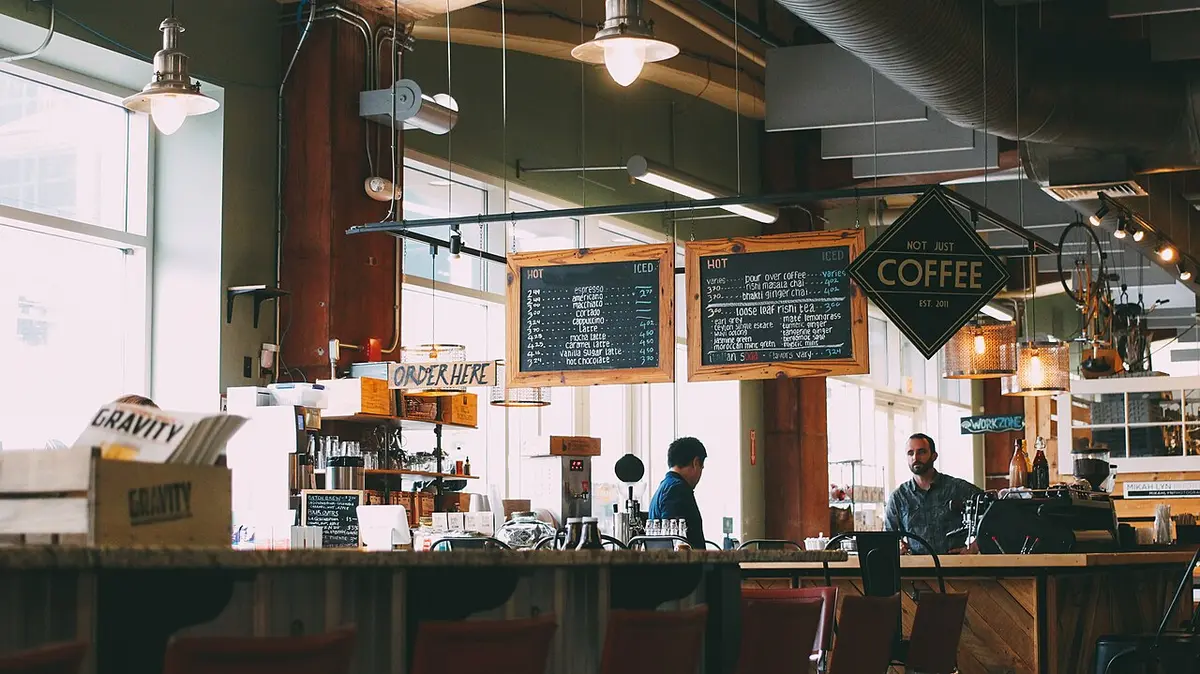 A coffee shop counter with menu boards and staff ready to take orders